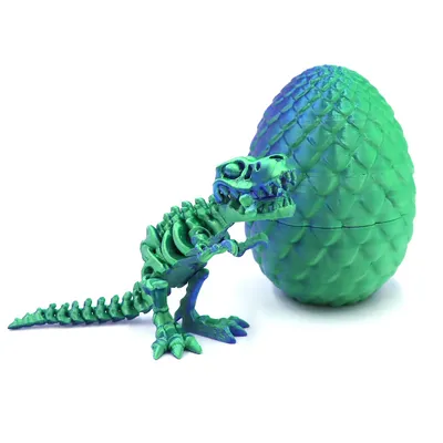 A 3D-printed dinosaur skeleton toy next to a dragon egg.