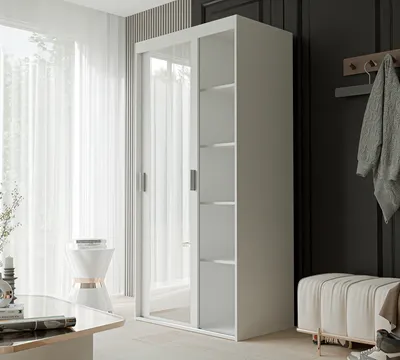 A white wardrobe with mirrored doors and open shelves is shown in a room with sheer curtains and a decorative stool.