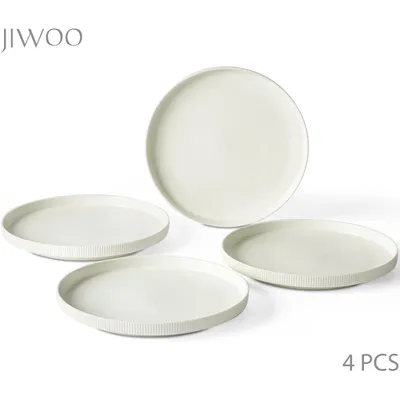 Four white ceramic plates are arranged on a white background. One plate is larger and positioned in the background, while three smaller plates are in the foreground.