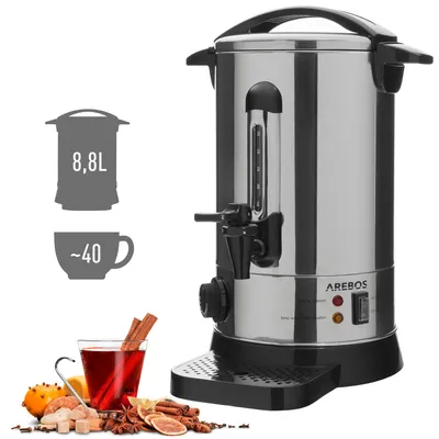 A stainless steel hot beverage dispenser with a glass water level indicator, a black dispensing tap, and control buttons. It is shown with decorative elements like oranges, spices, and a glass of mulled wine.