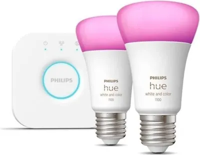 A white Philips Hue bridge and two white LED bulbs with pink light are shown against a white background.