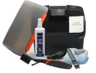 A collection of cleaning and maintenance tools for a robotic lawnmower, laid out on a white background.