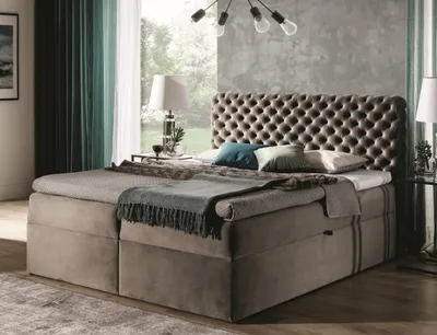 A bedroom scene with a large bed as the focal point, set against a textured wall and large windows with curtains.