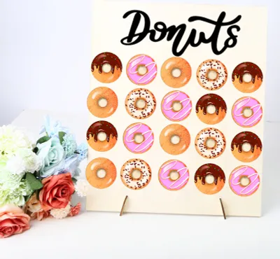 A donut display stand with donuts and a bouquet of flowers.