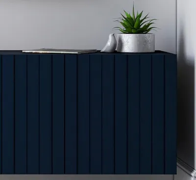 A close-up view of a navy blue cabinet with vertical slats, decorated with a small plant in a pot and a ceramic bird figurine.