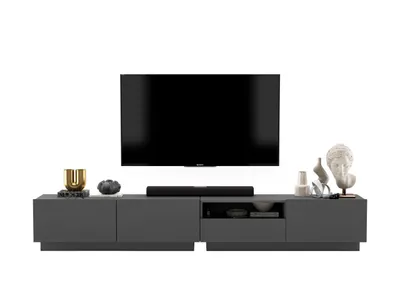 A modern TV stand with a television and decorative items.