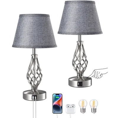 Two gray table lamps with silver bases are shown against a white background. One lamp has a hand icon pointing to its switch, indicating a touch feature. Accessories like a smartphone, earbuds, and light bulbs are also displayed.