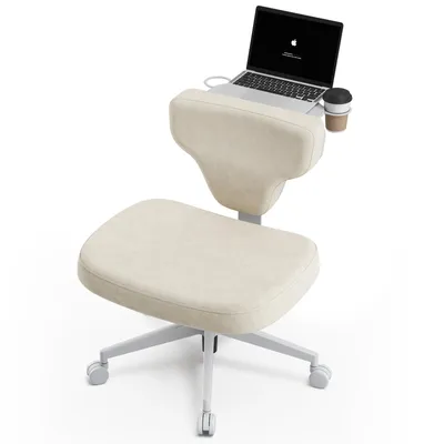 A cream-colored ergonomic chair with a laptop and a coffee cup on a tray attached to the backrest, set against a white background.