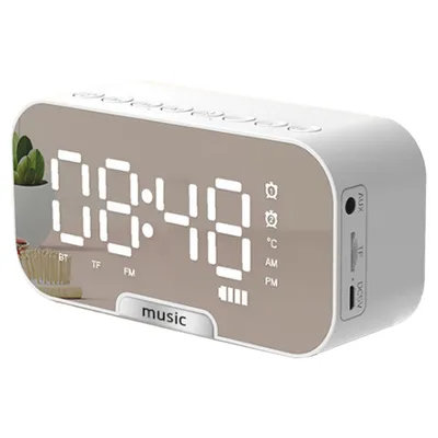 A white digital alarm clock with a mirrored display showing the time and other indicators.
