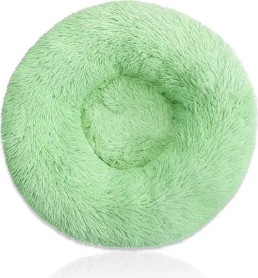 A round, fluffy, light green pet bed is shown against a white background.
