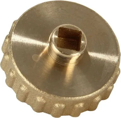 A close-up, studio shot of a brass cap with a square opening in the center.