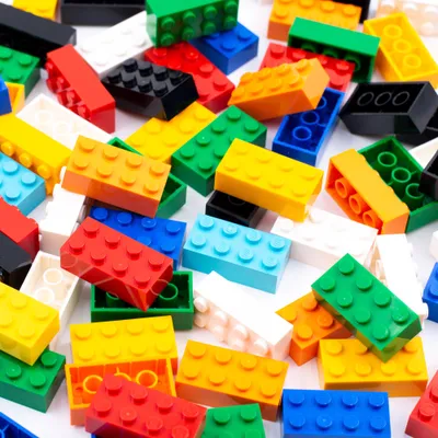A pile of colorful LEGO bricks on a white background.