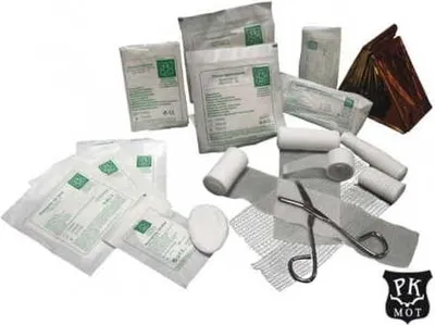 A collection of medical supplies, including bandages, gauze, and scissors, arranged on a white background.