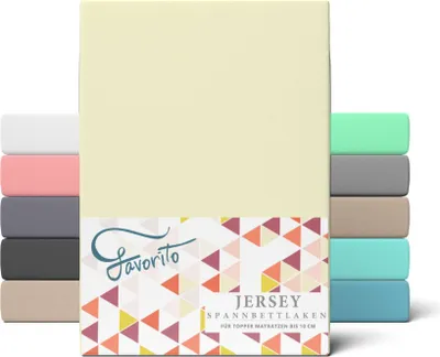 A stack of folded fitted sheets in various colors, with the main product in a light yellow color prominently displayed.