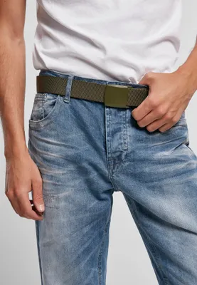 A person wearing a white t-shirt and blue jeans, with an olive green belt fastened around their waist.