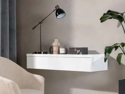 A modern living room setting with a floating shelf, a lamp, and a plant.