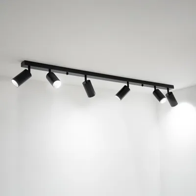 A black track light fixture with six adjustable spotlights mounted on a white ceiling.