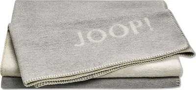 A stack of folded blankets with the brand name 'JOOP!' visible on the top blanket.