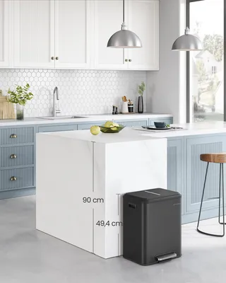 A modern kitchen with a white island and blue cabinets, featuring a black trash can next to the island.