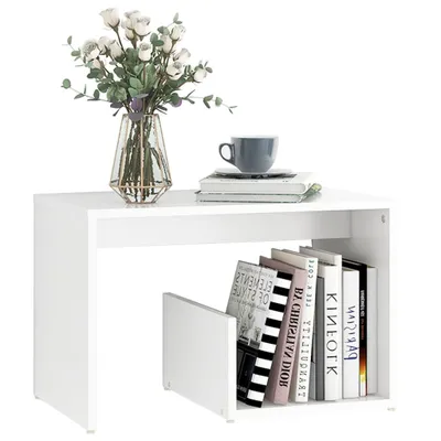 A white side table with books and a vase of flowers on top.