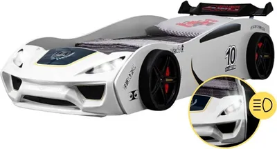 A white race car-shaped children's bed with a spoiler, displayed on a white background. A close-up inset shows the headlights.