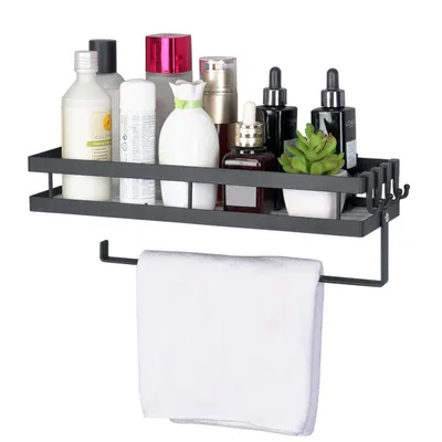 A black metal shelf with various cosmetic bottles and a small plant, with a white towel hanging from a bar below.