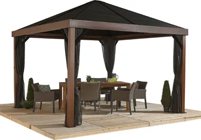 A gazebo with outdoor furniture set up inside, on a patio.