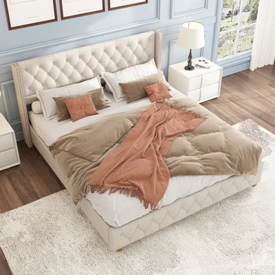 A bedroom scene with a tufted bed, nightstand, and lamp.