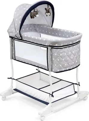 A baby bassinet with a canopy and a storage basket underneath, shown on a white background.