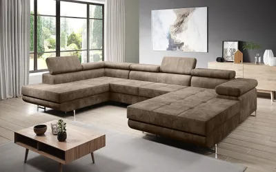 A spacious living room with a large sectional sofa, coffee table, and artwork on the wall.