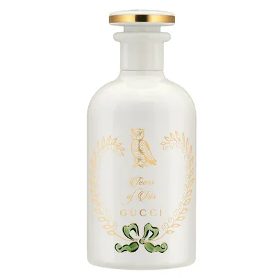 A white perfume bottle with gold and green accents.