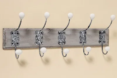 A wall-mounted coat rack with five hooks.