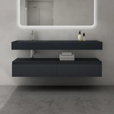 Modern bathroom vanity with a floating sink and drawers, illuminated mirror, and toiletries on the shelf.