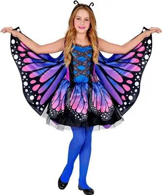 A young girl wearing a butterfly costume with wings, standing against a white background.
