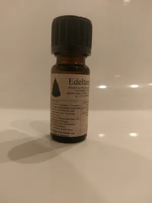 Kleine braune Flasche mit einem schwarzen Verschluss. Auf dem Etikett steht "Edeltanne".