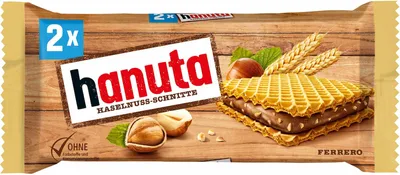 A package of Hanuta Haselnuss Schnitte wafers on a wooden background.