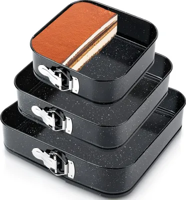 A stack of three black square springform pans, with the top pan containing a slice of tiramisu cake.
