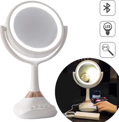 A white makeup mirror with LED lighting and a rose gold speaker base is shown against a white background. A smaller inset image shows the mirror on a desk with a hand touching it.