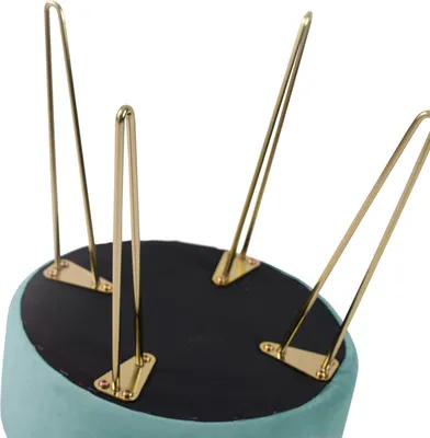 The underside of a teal ottoman with gold hairpin legs.