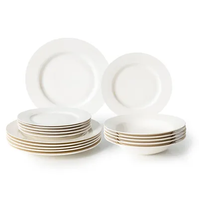 A set of white porcelain plates and bowls stacked on a white background.