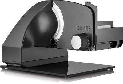 A black food slicer on a reflective black base.