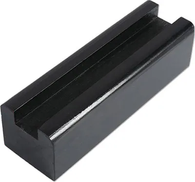 A close-up studio shot of a black object with a channel in the middle.