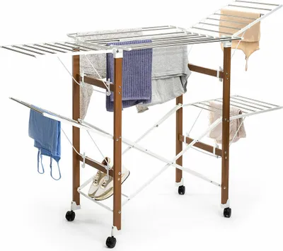 A foldable drying rack with clothes and shoes on it, set against a white background.