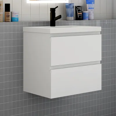 A white bathroom vanity with two drawers is mounted on a gray tiled wall.
