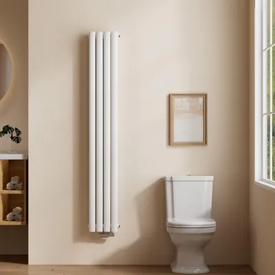 A vertical oval radiator is shown in a bathroom setting next to a toilet and a window.