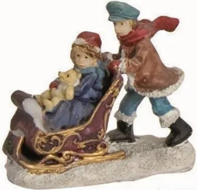 Niedliche Weihnachtsfigur die Mädchen zeigt das im Schlitten sitzt während ein Junge sie schiebt.