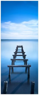 Produktbild von Wallario Premium Glasbild, freischwebende Optik, kräftige Farben, Größe 80 x 32 cm Motiv Rustikaler Holzsteg im blauen See