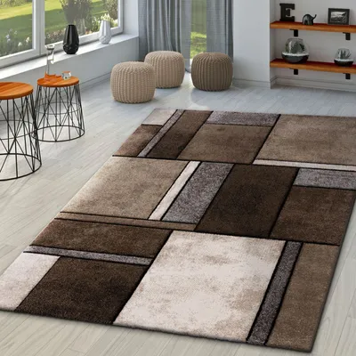 A modern living room with a geometric rug, side tables, and ottomans.