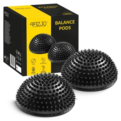 A product shot of two black balance pods with spikes, placed in front of their packaging.