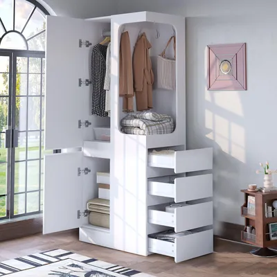 A white wardrobe with open doors and drawers, displaying clothes and folded blankets. The wardrobe is in a room with natural light coming from a large window.